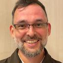 Das Bild zeigt einen Mann mit Brille und Bart.