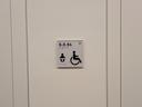Das Bild zeigt das Türschild der barrierefreien Toilette mit Wickelmöglichkeit in S.0.54.