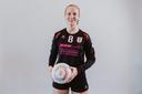 Eine junge Frau in Sportkleidung mit einem Ball in den Händen