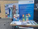 Eine Frau steht an einem farbenfrohen Stand.