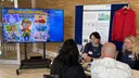 Studierende im Studiengang UP stellen interessierten Besuchern ihr Spiel vor "Mikroplastikdetektive"