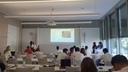 Ein Seminarraum in welchem Studierende einen Vortrag mit Power Point Präsentation vor anderen Studierenden halten