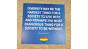 Auf einem blauen Bodensticker steht das Zitat von William Sloan Coffin Jr. "Diversity may be the hardest thing for society to live with and perhaps the most dangerous thing for a society to be without." Darunter ist ein Regenbogen-Herz