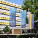 Das Bild zeigt den Haupteingang des TechCampus mit zwei HHN-Flaggen und einer Regenbogenfahne.