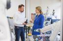 2 wissenschaftliche Mitarbeitende im Gespräch vor einem Robotergreifarm. 