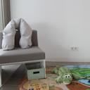 Das Bild zeigt den Sessel sowie Spielsachen im Eltern-Kind-Raum am Bildungscampus.