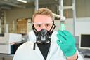 Student trägt aus Arbeitssicherheitsgründen eine Gasmaske, die vor Schwermetallen und anderen organischen Stoffen schützt.
