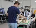 Ein Mann von hinten der einen Roboter bedient