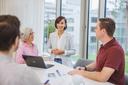 Two women and two men are talking in a work context.