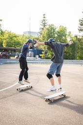The image depicts a situation of the "Sport im Park" initiative of the citiy of Heilbronn where the GECKO Longboard & Skateboard Lab offered a longboarding course
