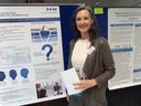 Monika Zellner steht vor einer Schautafel und blickt direkt in die Kamera 