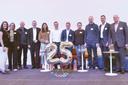 Eine Gruppe von Menschen auf einer Bühne, im Vordergrund Zahlenluftballons 25