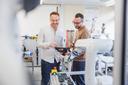 2 Wissenschaftlich Mitarbeiter bedienen ein Panel um einen Roboter zu steuern.labor