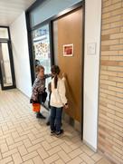 Das Bild zeigt Kinder die vor einer Bürotüre warten
