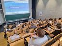 Eine Menge Menschen in einem Stufenhörsaal bei einem Vortrag