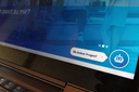 Laptop-Tastatur und Bildschirm mit Chatbot-Symbol und Text 'Sie haben Fragen'?