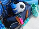 Verschiedene Sportgeräte wie Tennisschläger, Fußball, Springseil und eine Gymnastikmatte 