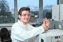 Ein Student im weißen Laborkittel und mit Schutzbrille arbeitet konzentriert an einem Gaschromatographen im Labor für Umwelt- und Prozessanalytik der Hochschule Heilbronn. Er bereitet gerade eine Probe für die analytische Untersuchung vor.
