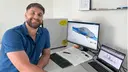 Masterstudent Dominik Ehrlich am Computer. Auf dem Bildschirm sieht man die Simulation eines Autos
