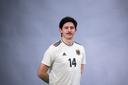 Ein junger Mann in einem Fußballtrikot.