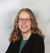 Das Bild zeigt eine Frau mit Brille und langen Haaren